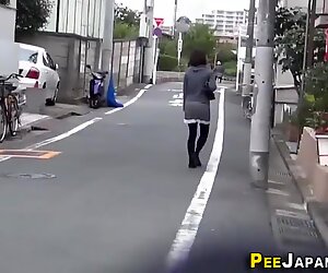 Asian babe pisses outside